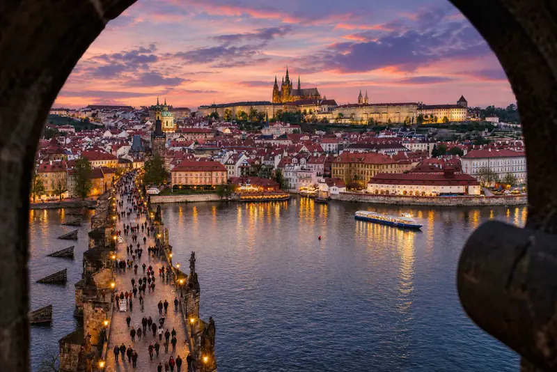 Večerní Karlův most a Pražský hrad z mostecké věže